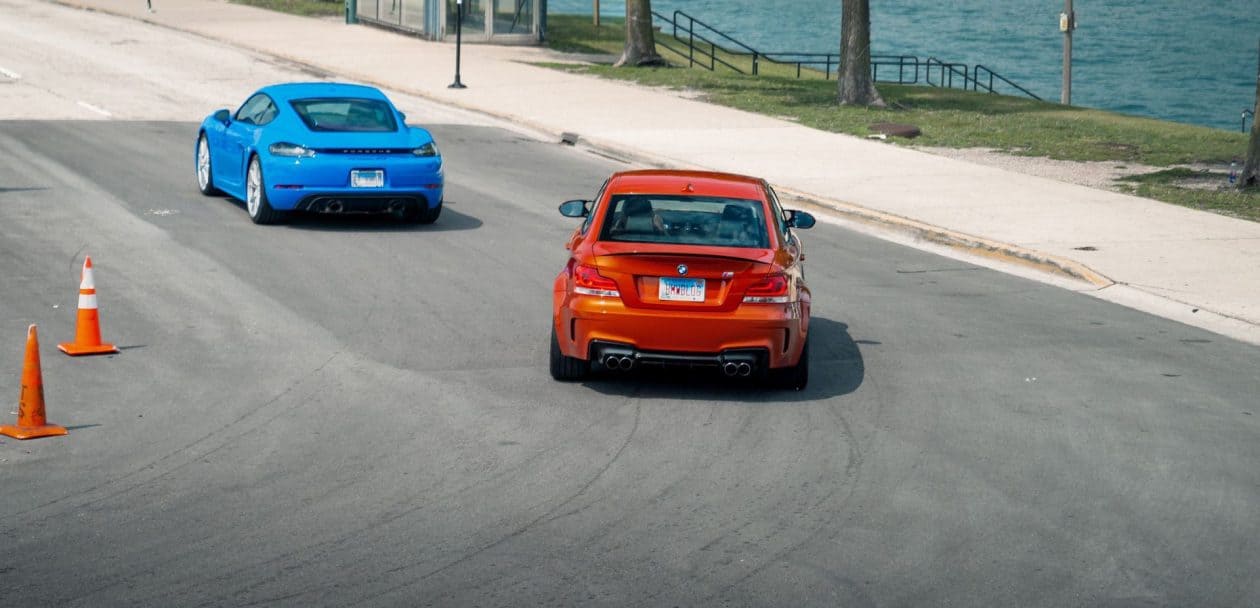 BMW 1M VS PORSCHE CAYMAN GTS DRIVING BY THE LAKE