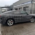 BMW iX4 prototype with camouflage reveals sloping roofline and rakish coupe proportions